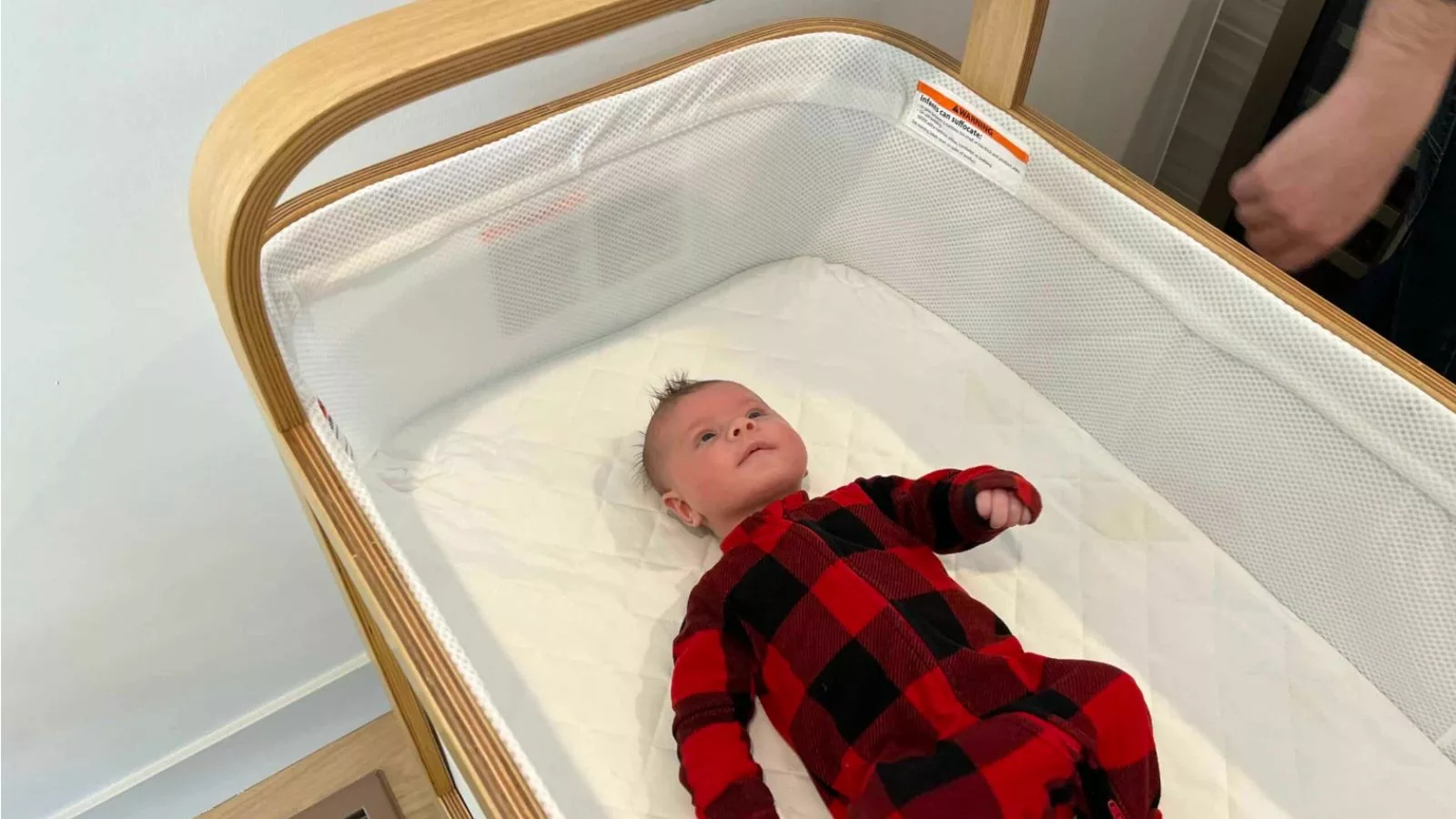 A baby in red pajamas in the Cradlewise Smart Crib