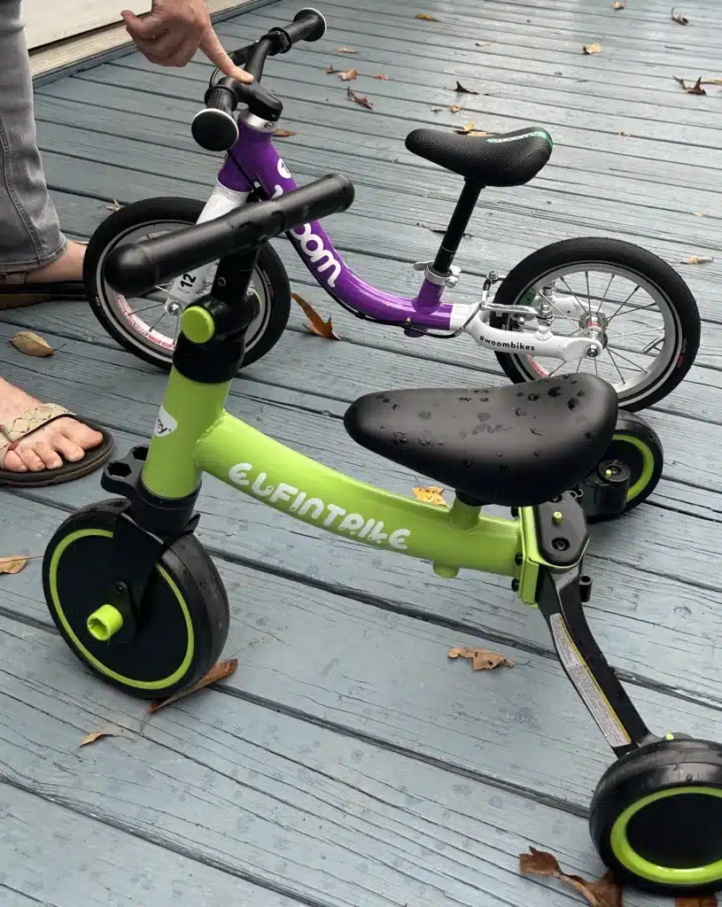 A green Elfintrike tricycle and a purple Woom side by side